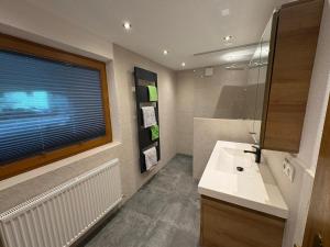 a bathroom with a white sink and a window at Apartment Tirol #Spielanger Hof# in Weer +4 photos
