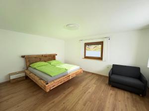 a bedroom with a bed and a chair in it at Apartment Tirol #Spielanger Hof# in Weer