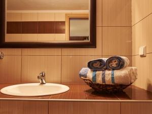 a bathroom with a sink and a bowl with towels at Toroni Dreams in Toroni