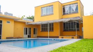 a house with a swimming pool in front of it at Casa de los Abuelos in Itzamatitlán