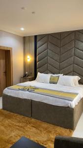 オウェリにあるHotel Enigmaのベッドルームに大型ベッド1台(大型ヘッドボード付)