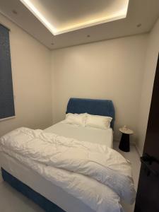 a small bedroom with a bed with a blue headboard at المعتلية in Riyadh