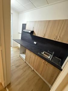 una cocina con encimera negra y armarios de madera en Orléan 41 B centre-gare-aéroport, en Charleroi