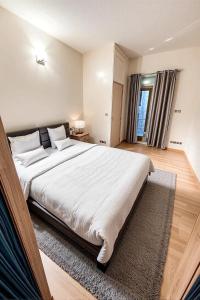 Un dormitorio con una gran cama blanca con ventana. en Orléan 41 B centre-gare-aéroport, en Charleroi