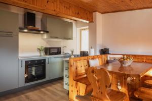 San Nicolò di ComelicoAl Piol的厨房配有木桌和木椅