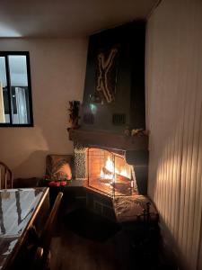 a living room with a fire in a fireplace at Le Hourmigué maison 130m2 avec jacuzzi à 15mn de Luchon in Cierp