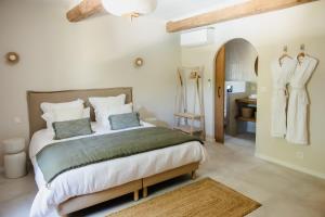 a bedroom with a large bed and a bathroom at La Bastide de Monique - Maison d'hôtes en Provence in Flassans-sur-Issole