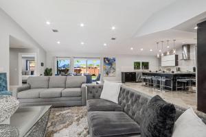 a living room with a couch and a kitchen at Spacious 6BR Beach Getaway w Heated Pool in Barwal