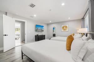 a white bedroom with two beds and a window at Spacious 6BR Beach Getaway w Heated Pool in Barwal +60 photos