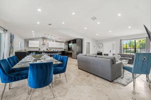 a dining room and living room with a table and blue chairs at Spacious 6BR Beach Getaway w Heated Pool in Barwal