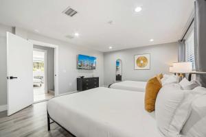 una camera da letto bianca con due letti e una finestra di Heated Pool Putting Green 5 min from Beach a Barwal Altre 46 foto