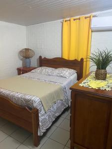 a bedroom with a bed and a yellow curtain at Bleu Ocean in Deshaies +11 photos