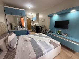 a bedroom with a large bed with a blue wall at Standard Room at 8 Spatial by Forever-mc Condotel 8335 in Davao City