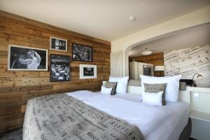 a bedroom with a large white bed with wooden walls at Nägler´s Fine Lounge Hotel in Oestrich-Winkel +35 photos