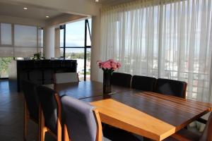 a dining room table with chairs and a vase of flowers at Penthouse with Glass Floor and Volcano View in Cholula
