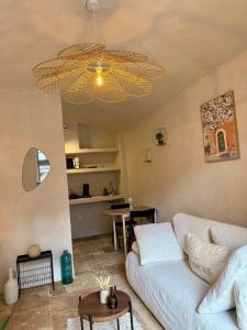 sala de estar con sofá blanco y lámpara de araña en La Douceur du Fort - Parking, extérieur, vue, en Mercury