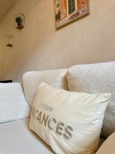 Un sofá blanco con una almohada con las palabras "justicia daña" en La Douceur du Fort - Parking, extérieur, vue, en Mercury