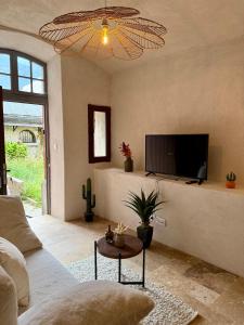 Una sala de estar con un sofá y un televisor. en La Douceur du Fort - Parking, extérieur, vue, en Mercury