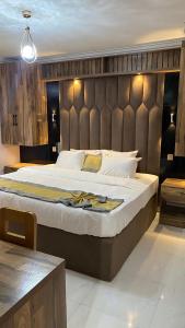 オウェリにあるHotel Enigmaのベッドルーム1室(大型ベッド1台、パッド入りのヘッドボード付)