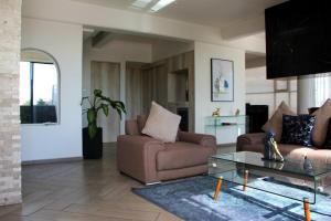 a living room with two couches and a glass table at Penthouse with Glass Floor and Volcano View in Cholula