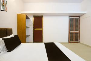 Un dormitorio con una cama con una manta blanca y negra. en Hotel O Agrawal Inn, en Jabalpur