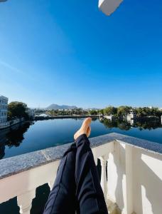 un hombre sentado en un puente mirando el agua en The Haveli Stays Udaipur, en Udaipur