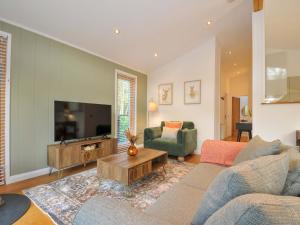 a living room with a couch and a tv at 6 Stonerush Valley in Looe