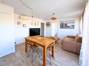 Una sala de estar con una mesa de madera y un sofá. en Evasion Marine - Appartement en premiere ligne plage, climatise et parking, en Mauguio 8 fotos más