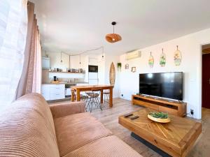 una sala de estar con un sofá y una mesa en Evasion Marine - Appartement en premiere ligne plage, climatise et parking, en Mauguio
