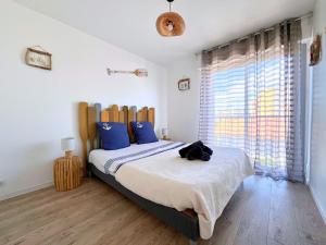 Un dormitorio con una cama grande con almohadas azules. en Evasion Marine - Appartement en premiere ligne plage, climatise et parking, en Mauguio