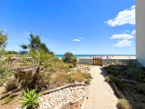 Un camino a la playa con el océano al fondo. en Evasion Marine - Appartement en premiere ligne plage, climatise et parking, en Mauguio