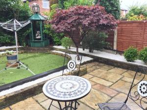 a patio with a table and chairs in a garden at room 02 chesterton Grove in Manchester