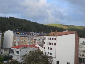 a city with buildings and a mountain in the background at Ático Formoso in Cee