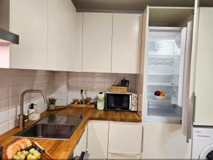 a kitchen with white cabinets and a microwave at Ático Formoso in Cee