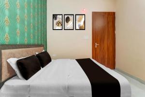 Un dormitorio con una cama con tres cuadros en la pared. en Hotel O by OYO Swastik inn, en Gwalior 12 fotos más