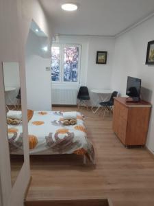 a bedroom with a bed and a desk with chairs at Spital 1 camera etaj 2 in Târgu-Mureş +2 photos