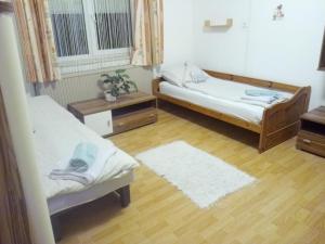 ein Zimmer mit zwei Betten und Holzboden in der Unterkunft Holi in Erlauf