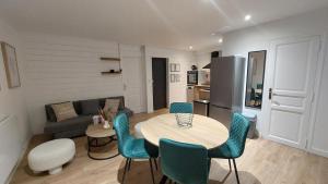 a living room with a table and chairs and a couch at Appartement MVM Jacuzzi proche Saint-Malo in Plouër-sur-Rance
