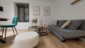 a living room with a couch and a table and a chair at Appartement MVM Jacuzzi proche Saint-Malo in Plouër-sur-Rance