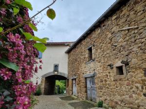 Außenansicht eines Steingebäudes mit rosa Blumen in der Unterkunft Grand T2 pour Curistes à DUC MANOIR in Aubin