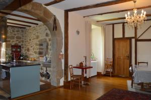 eine Küche mit einer Steinwand und einem Tisch mit Stühlen in der Unterkunft Grand T2 pour Curistes à DUC MANOIR in Aubin