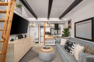 a living room with a couch and a large tv at Seabatical on The Strand in Manhattan Beach