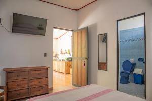 埃斯孔迪多港Casa Helechos的一间卧室配有一张床和一个梳妆台,还设有一间浴室