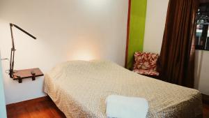 埃斯孔迪多港Casa Helechos的卧室里有一张床、一盏灯和一把椅子