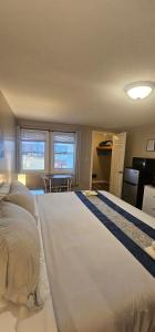 um quarto com uma cama grande com lençóis brancos em Lake Shore Farm Inn em Northwood