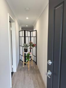 a hallway with a table with flowers and a mirror at The Margs Hideaway Ensuite in Margaret River Town