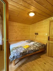 a bed in a wooden room in a cabin at Chata U Hýka in Ludvíkov