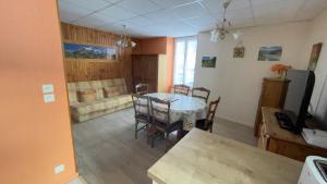a living room with a table and chairs and a couch at Les cascades in Le Mont-Dore