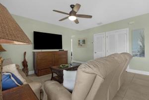 een woonkamer met een bank en een flatscreen-tv bij Coastline Comfort in Key West +52 foto's