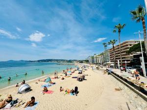 un grupo de personas en una playa cerca del océano en L'Eden Apt 4 Prs, clim, parking, 300 m des plages, en Antibes